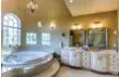  ??  ?? The six-piece master-bedroom ensuite includes a step-up soaker oval tub and a vaulted ceiling.
