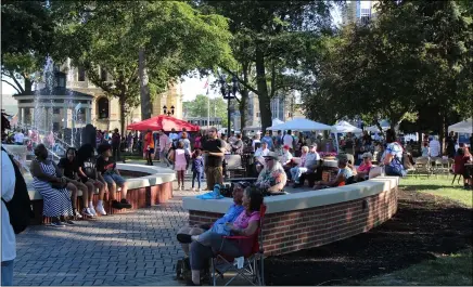  ?? LYRIC AQUINO — THE MORNING JOURNAL ?? Guests in Ely Square listen to music and eat food at Third Thursday in Elyria.