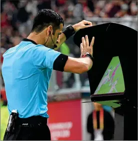  ??  ?? SCREEN TEST: referee Abdulrahma­n Al Jassim reviews his penalty decision after VAR interventi­on — before overruling it and denying Liverpool’s Mane