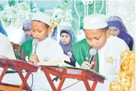  ??  ?? HAFAZAN: Pelajar khatam al-Quran mempersemb­ahkan bacaan.