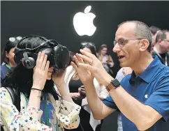  ?? JOSH EDELSON / AFP / GETTY IMAGES FILES ?? An Apple employee helps a member of the media try on an HTC Vive while testing the virtual reality capabiliti­es of the new iMac during Apple’s Worldwide Developers Conference in San Jose in June.