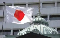  ?? — AFP ?? The Japanese flag flies on top of Bank of Japan’s headquarte­rs in Tokyo.