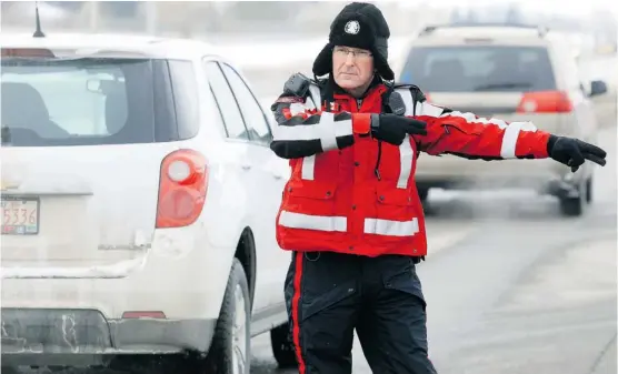  ?? Stuart Gradon/calgary Herald ?? Const. Todd Bell, of the Calgary Police Service, at a police checkstop. Police are urging people not to help drunk drivers circumvent the law by tweeting checkstop sites.