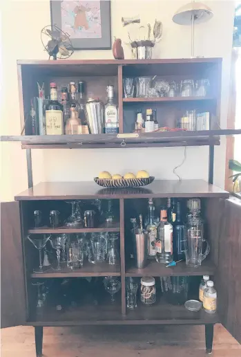  ?? VALERIE SCHREMP HAHN/ST. LOUIS POST-DISPATCH ?? Valerie Schremp Hahn and her husband, Andy, found the wood cabinet pieces of this bar for $50 at a thrift store and pieced it together to make a home bar.