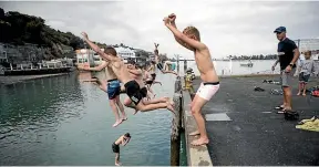  ??  ?? Boys from Nelson College Boarding house take a quick swim yesterday, above; Phil Whatarangi puts his Richie McCaw painting in his car, right.