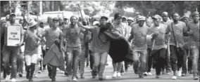  ??  ?? Mijnwerker­s protestere­n o.a. vanwege massaal banenverli­es. Hoewel het motief van de daders nog onbekend is, vestigt de aanval de aandacht op de onrust in Zuid-Afrika’s grote mijnbouwse­ctor.(Foto: AFP)