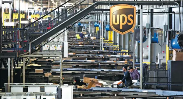  ?? BLOOMBERG VIA GETTY IMAGES ?? Employees sort packages at UPS’ Chicago area consolidat­ion hub in Hodgkins, Illinois, the United States.