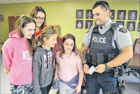  ?? ERIC MCCARTHY/JOURNAL PIONEER ?? Const. J.P. Cote shows Suzanne Getson and children, from left, Ella Gavin, Amiyah Getson and Mary Jane Gavin Shea, the Narcan kit containing naloxone that officers carry in case they are exposed to the drug, fentanyl. During an informatio­n session on...