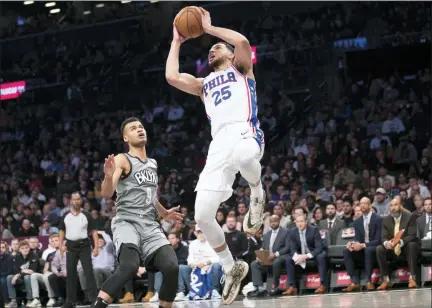  ?? MARY ALTAFFER — THE ASSOCIATED PRESS ?? Philadelph­ia 76ers guard Ben Simmons (25) goes to the basket past Brooklyn Nets guard Chris Chiozza (9) during the first half of an NBA basketball game, Monday in New York.