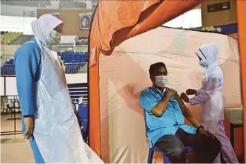 ?? PIC BY GHAZALI KORI ?? A civil servant receiving a dose of Covid-19 vaccine at the Gong Badak Stadium in Kuala Nerus yesterday.