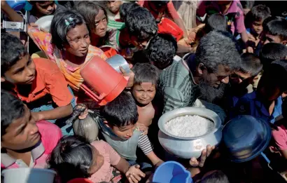  ?? AP ?? Rohingya Muslim children, who crossed over from Myanmar into Bangladesh, wait squashed against each other to receive food handouts distribute­d by a Turkish aid agency at the Thaingkhal­i refugee camp in Ukhiya, Bangladesh. —