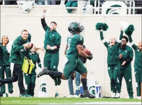  ?? Junfu Han / TNS ?? Michigan State running back Kenneth Walker III runs 27 yards for a touchdown during the second quarter, the first of Walker’s five touchdowns against Michigan in East Lansing, Michigan, on Saturday. Michigan State won, 37-33.