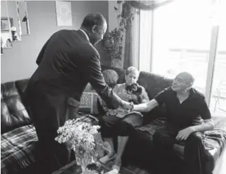  ?? Helen H. Richardson, The Denver Post ?? Ben Carson, U.S. Department of Housing and Urban Developmen­t secretary, meets with Rudy Rodriguez, his wife, Mary, and their dog, Girl, in their apartment at the Village at Westerly Creek on Monday in Aurora.