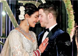  ??  ?? Bollywood actress Priyanka Chopra and her husband singer Nick Jonas pose during a photo opportunit­y at their wedding reception in New Delhi