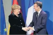  ?? AP ?? German Chancellor Angela Merkel and French President Emmanuel Macron shake hands in Berlin on Sunday.