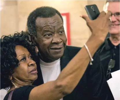  ?? ASHLEE REZIN/SUN-TIMES ?? Mayoral candidate Willie Wilson takes a selfie with a woman waiting in line for up to $500 in property tax assistance from the Dr. Willie Wilson Foundation on Wednesday outside the Cook County treasurer’s office.
