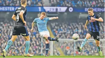  ??  ?? Kevin De Bruyne (centre) shoots between Rotherham’s Will Vaulks (left) and Michael Smith (right) during the English FA Cup third round football match between Manchester City and Rotherham United at the Etihad Stadium. — AFP photo