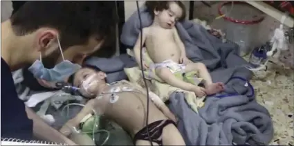  ??  ?? This image made from video released by the Syrian Civil Defense White Helmets, which has been authentica­ted based on its contents and other AP reporting, shows medical workers treating toddlers following an alleged poison gas attack in the...