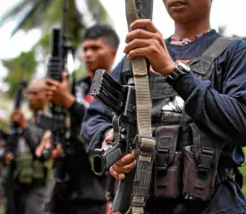  ?? —KARLOSMANL­UPIG ?? New People’s Army rebels stand in attention at ceremonies for the release of militiamen Rene Doller and Carl Mark Nucos on March 25.