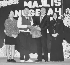  ??  ?? Melvin (second left) and her mother (left) accept his award for Best PPKI student award from Ahmad and Suhaila.