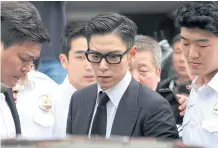  ??  ?? T.O.P., a member of the Korean idol group Big Bang, leaves court in Seoul after receiving a 10-month suspended sentence for smoking marijuana in July last year.