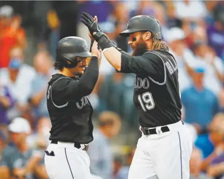  ?? David Zalubowski, The Associated Press ?? Rockies catcher Tony Wolters, left, congratula­tes Charlie Blackmon as he crosses home plate after the right fielder hit a two-run homer off Chicago Cubs starting pitcher Yu Darvish during the third inning Monday night at Coors field.