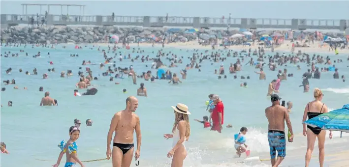  ?? EFE ?? Playa a pleno. Los bañistas disfrutan, ayer, un día de sol y muy caluroso en Miami Beach. Los expertos reprocharo­n la violación de todas las medidas de seguridad sanitaria.