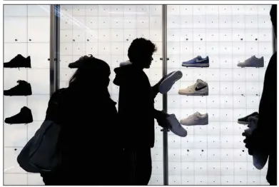  ?? (AP) ?? People shop for shoes in a Nike store on black Friday in New York. Nike’s global revenue rose 17% to $13.3 billion in the quarter that ended Nov. 30, about $700 million more than projected.