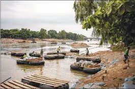  ?? CESAR RODRIGUEZ NYT ?? Workers use rafts to transport merchandis­e across the Suchiate River between Mexico and Guatemala.