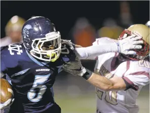  ?? JIM GENSHEIMER/STAFF ?? Valley Christian’s D’Angelo McKenzie gives Cardinal Newman’s Kyle Carinalli a stiff arm on a punt return during Friday’s 31-6 NorCal Division 2-AA playoff win for the Warriors.