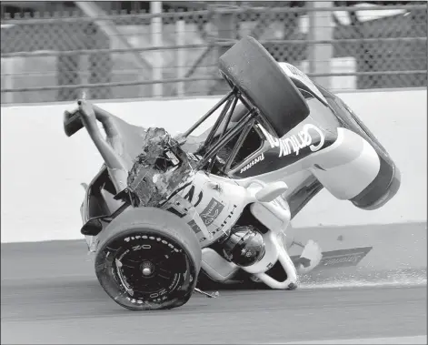  ?? AP/MARTY SEPPALA ?? Josef Newgarden’s car slides after crashing and flipping over in practice Thursday at Indianapol­is Motor Speedway. Helio Castroneve­s had a similar crash Wednesday. Neither driver was injured.