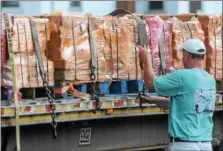  ?? JOHN STRICKLER — DIGITAL FIRST MEDIA ?? Thousands of bricks are being brought into Boyertown from Pitcairn. These bricks will be installed in specific patterns along the railroad station platform. Here, John Glanfield, a volunteer with the Colebrookd­ale Railraod loosens straps on the first...