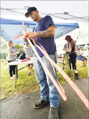  ?? Peter Hvizdak / Hearst Connecticu­t Media ?? Adrian Everett, of Wallingfor­d, goes over his raffle tickets during the second Physical Freedom Festival fundraiser on Saturday at the North Haven Fairground to benefit Spina Bifida research. Despite the rain, many activities were brought inside the fairground barn that included local bands who provided entertainm­ent. Spina Bifida is a birth defect in which there is incomplete closing of the backbone and membranes around the spinal cord.