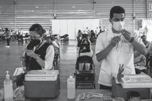  ?? Jeoffrey Guillemard / Bloomberg ?? Health care workers prepare doses of the Sinovac Biotech vaccine July 28 in Mexico City.