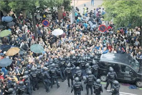  ?? Photograph­s by Emilio Morenatti Associated Press ?? SPANISH national police bar access to a school in Barcelona designated as a polling site by the regional government in Catalonia.