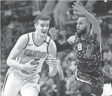  ?? MICHAEL CHOW/THE REPUBLIC ?? Suns forward Dragan Bender drives against Spurs guard Patty Mills during the first quarter at Talking Stick Resort Arena in Phoenix on Wednesday.