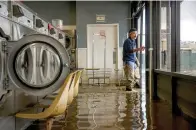  ?? (Brontë Wittpenn/San Francisco Chronicle via AP) ?? Patrick Cerruti assesses damage of his daughter’s flooded laundry mat, Pajaro Coin Laundry on Tuesday at Salinas Road in Pajaro, Calif. A levee failure prompted overnight evacuation­s on Friday and into the next day.