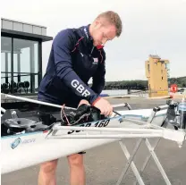  ??  ?? Preparatio­n Tom Young prepares a rowing boat for launch