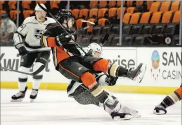  ?? Mark J. Terrill Associated Press ?? THE DUCKS’ Ben Hutton, center, collides with the Kings’ Dustin Brown in a matchup of rivals rebuilding at different speeds. Anaheim GM Bob Murray said before the game that “I expected to be better and we’re not.”