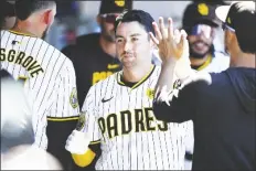  ?? DENIS POROY/AP ?? SAN DIEGO PADRES’ KYLE HIGASHIOKA is congratula­ted after hitting a solo home run during the fourth inning of a game against the St. Louis Cardinals on Wednesday in San Diego.