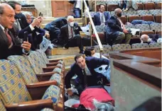  ?? ANDREW HARNIK/AP ?? People shelter in the House gallery Jan. 6 as rioters try to break into the House Chamber at the U.S. Capitol.