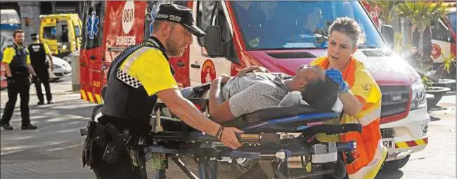 ?? EFE/Quique García ?? Un policía y una profesiona­l médica de emergencia­s trasladan a uno de los heridos el 17 de agosto de 2017 tras el atentado en Las Ramblas