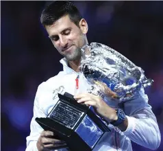  ?? — Photo by AFP ?? THE GOAT . . . An emotional Novak Djokovic proudly displays the Australian Open men’s singles trophy after overcoming a hamstring injury and off-court drama on his return to Melbourne Park to sweep past Greek third seed Stefanos Tsitsipas 6-3, 7-6 (7/4), 7-6 (7/5) on Rod Laver Arena yesterday . The Serb was overcome with emotions after winning at Melbourne Park just one year after he was controvers­ially deported from Australia for not being vaccinated against Covid-19.