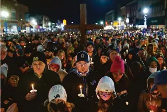  ?? Ryan Garza / Detroit Free Press ?? Thousands of people gather for a vigil Friday night in Oxford, Mich., following a shooting attack last Tuesday that killed four students and injured seven others at Oxford High School.
