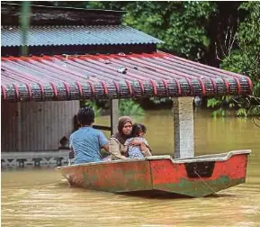  ?? (Foto Ghazali Kori/bh) ?? Penduduk menaiki sampan ke rumah mereka yang ditenggela­mi banjir di Kampung Permaisuri, Hulu Terengganu.