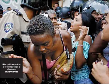  ??  ?? Riot police control a crowd outside a Caracas supermarke­t Venezuelan debt payments coming due through 2020