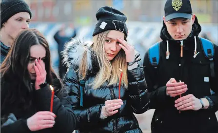  ?? ALEXANDER ZEMLIANICH­ENKO THE ASSOCIATED PRESS ?? People in Moscow hold the candles to commemorat­e the victims of Sunday’s fire in a shopping mall in the Siberian city of Kemerovo.