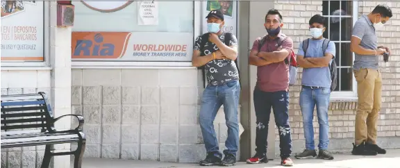  ?? NICK BRANCACCIO ?? Temporary foreign farm workers line up outside a money transfer business in downtown Leamington on payday. Windsor-essex has about 8,000 migrant farm workers.