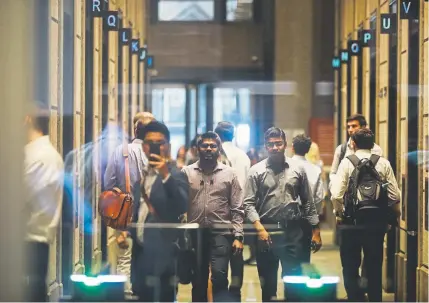  ?? Spencer Platt, Getty Images North America ?? People walk in the lobby of Deutsche Bank's Manhattan headquarte­rs following news that the global banking giant will be letting go of thousands of employees due to a major restructur­ing at the German bank on Tuesday in New York City.