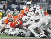  ?? Tim Heitman Associated Press ?? OKLAHOMA STATE’S Dezmon Jackson (27) is stopped short of the goal line by Baylor defenders.